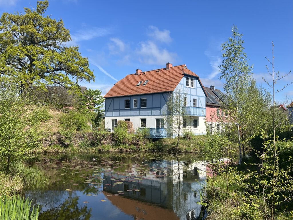 Haus mit See im Vordergrund Beech Resort Fleesensee