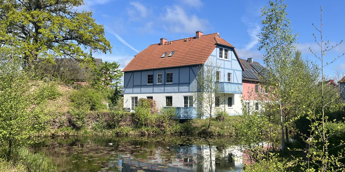 8_a Haus mit See im Vordergrund Beech Resort Fleesensee